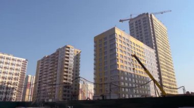 Birçok yüksek binalar ve sarı inşaat vinci.