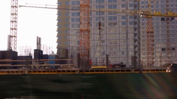 Żuraw podnosi metalową ramę na placu budowy. — Wideo stockowe