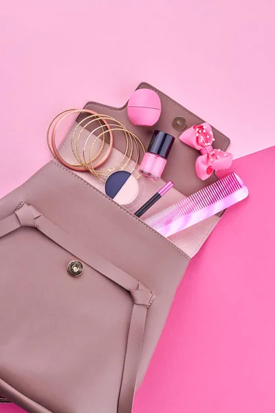 Female backpack with cosmetics and makeup accessories on color background. Flat lay and top view.