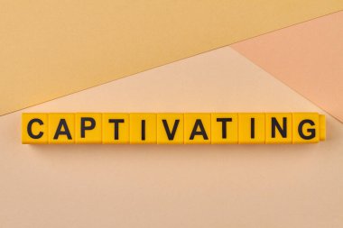 Işık arkaplanda alfabe bloklarına yazılmış büyüleyici bir kelime. Çekici ve ilgi çekici, büyüleyici..