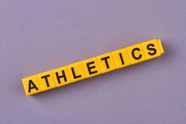 Mor Arka Planda Kelime Atletizmi Olan Sarı Küplere Spor Sağlıklı — Stok fotoğraf