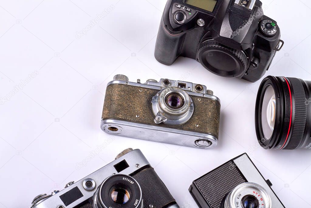 Many various different retro photo cameras on white background. Old-fashioned cameras closeup-up.