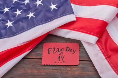 Birleşik Devletler bayrağı 14 Haziran günü ahşap masada. Çizgili ve yıldızlı kumaş pankart.