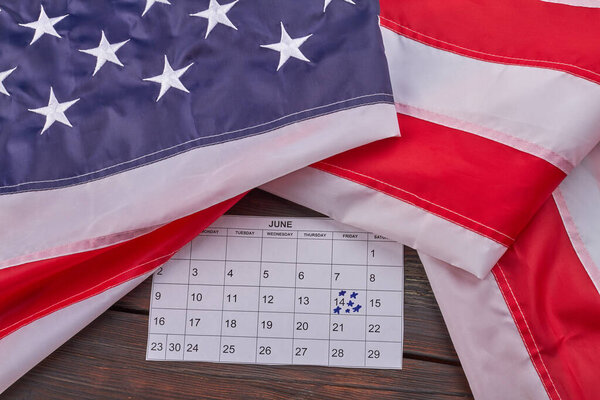United states flag with calendar with marked june 14th. Top view flat lay.