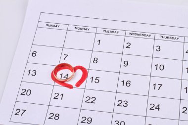 Üzerinde 14. gün ve altın alyans olan bir takvim. Üst görünüm düzlüğü.