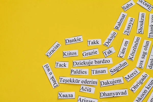 Thank you in many different languages arranged in a heart. Isolated on yellow background.