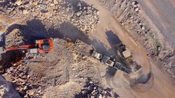 挖掘机在倾卸卡车上装了一块石头 从无人机俯瞰空中 矿产品运输的采矿设备 — 图库视频影像