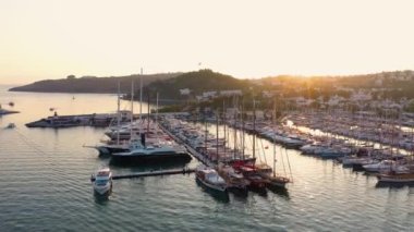 Bodrum kasabası ve limandaki teknelerin günbatımı görüntüleri. Akdeniz kıyısındaki tatil köyünün güzel hava manzarası.