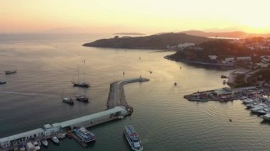 Türkiye 'nin Ege kıyısındaki Bodrum Limanı. Yukarıdan havadan panoramik görüntü. Şehrin üzerinde güzel turuncu gün batımı ve arka planda dağlar.
