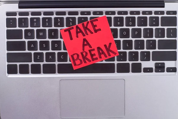 Paper with message take a break on keyboard. Urge for hard worker.