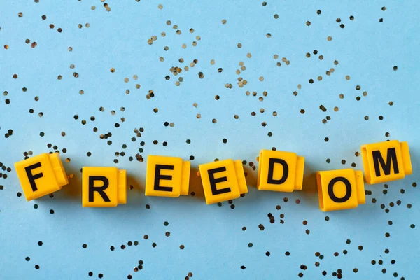 Gelber Buchstabenwürfel Blockiert Das Wort Freiheit Viele Pailletten Auf Blauem — Stockfoto