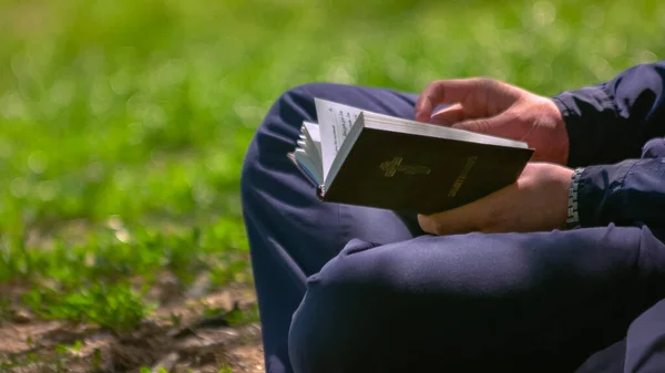 Primer Plano Joven Sosteniendo Una Biblia Sus Manos Sentado Parque — Foto de Stock