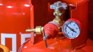Close-up of large red ballong with pressure indicator. Propane storage containers.
