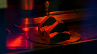 Kırmızı yıldırımlı metal makine bileşenlerine yakın çekim. Soyut makine çelik döküntüleri kırmızı ışıkla karanlık odada..