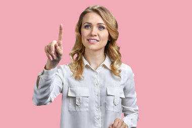 Renkli arka planda sanal ekranla çalışan güzel bir iş kadını. Sanal ekranda güzel bir ofis kadını düğmeye basıyor.