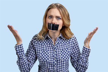 Ağzında siyah bantla kadın protestocu. Renkli arka planda protesto gösterisi yapıyor. Ağzı bantlı kadın portresi.