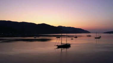 Boats in the sea at sunset in summer. Mountains and sky in the background. Beautiful marine landscape. Go everywhere.