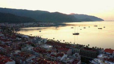 View of resort city from above. Beautiful cityscape, sea bay and mountains at sunset. Marmaris, Turkey.