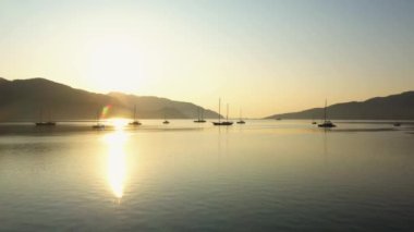 Many boats on calm sea surface with sun reflection on water. Beautiful sunrise on tropical island. Go everywhere.
