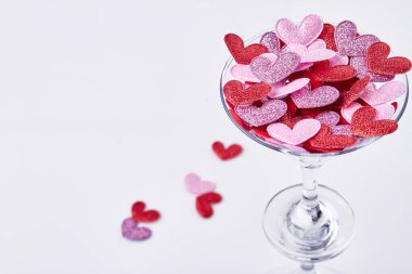 Close up cocktail glass filled with hearts. Valentines day concept. Isolated on white background.