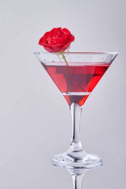 Vertical shot red cocktail with rose flower. Isolated on white background.