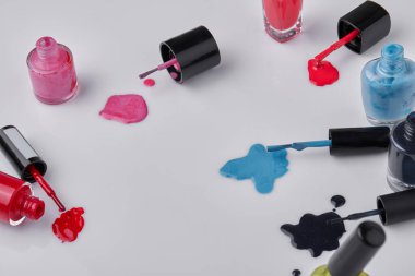 Set of various colorful nail polishes on white. Spilled multicolored paint.