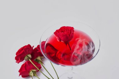 Close up red cocktail and rose flowers. Isolated on white background.