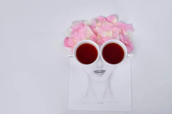 Hand drawn female face with petal hair. Cups of tea instead of eyes.
