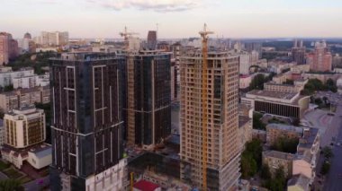 Tower construction site with cranes and buildings in the big city. Aerial top view.