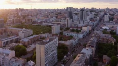 Aerial view of city buildings with car traffic during sunset. Urban cityscape background.