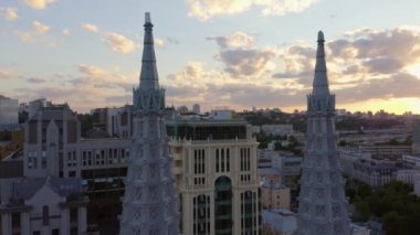 Big city urban cityscape with evening sunset sky. Decorative Roman Catholic Church of St. Nicholas.