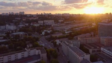 Aerial top view of evening cityscape with sunset light. Buildings and trees.