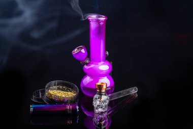 Glass bong with mj weed smoke and glass pipe with lighter. Light drug smoking concept.