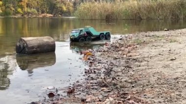 RC flatbed towing truck going on ponds shallow water. High passibility radio controlled vehicle.