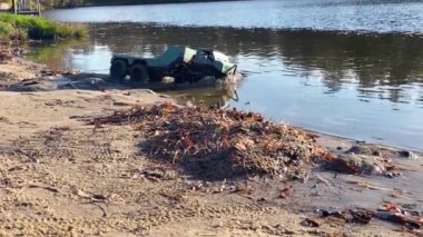 RC vehicle moving on shallow water and making waves in slow motion. Radio controlled flatbed towing truck.