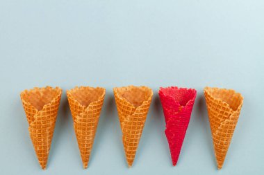Kırmızı külahlı waffle sıradan olanlardan. Mavi pastel arkaplan.