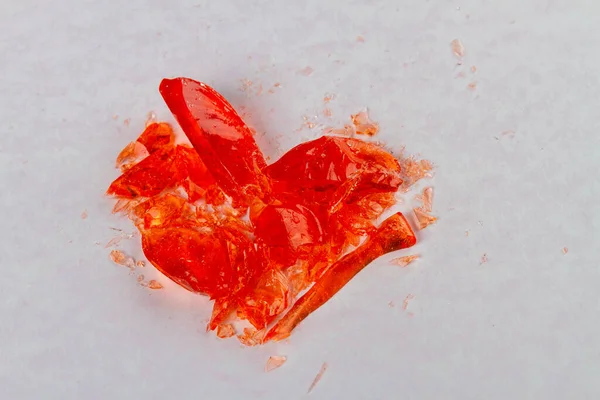 Close up broken heart lollipop on white surface. Broke up concept.