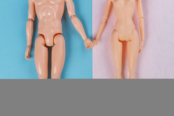 裸の人形のカップルの手を保持トップビュー 青とピンクの背景 — ストック写真