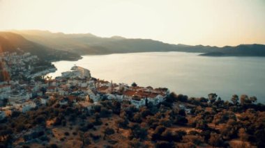 Deniz ve tatil köyünün gün batımı manzarası. Yukarıdan güzel bir manzara. Seyahat ve tatil kavramı.