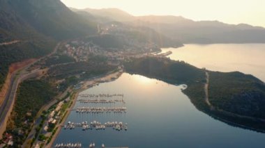 Sabahları parkedilmiş yat ve teknelerle deniz manzarası. Deniz ve dağlarla çevrili güzel bir tatil köyü..