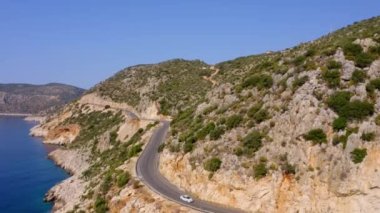 Kıvrımlı okyanus yolunun ve yüksek yeşil dağların üst manzarası. Seyahat ve tatil kavramı.