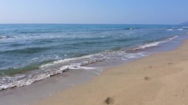 Kumlu sahilde mavi deniz dalgaları. Doğa geçmişi. Deniz tatili kavramı.