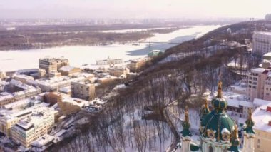 Dinyeper Nehri ve Andreevskaya Kilisesi 'nin kışın insansız hava aracı görüntüsü. Karla kaplı şehrin manzarası.