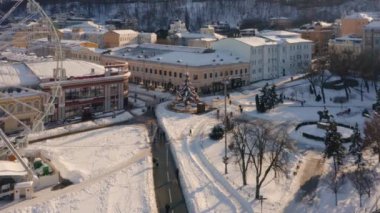 Kontraktova kare dönme dolap ve dönen Noel ağacı. Kiev şehri karla kaplı..