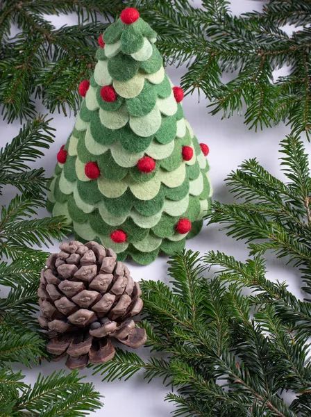 Christmas toy tree surrounded with real fir branches and christmas decorations — Stock Photo, Image