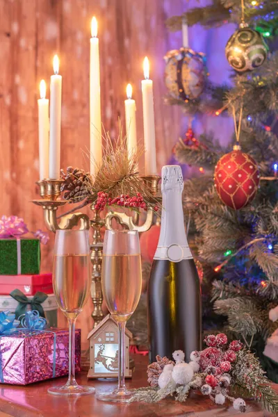 stock image Glasses of champagne and gifts composition with lit up candelabra .