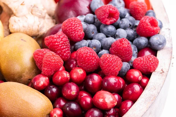 Tahta tepsi taze sebzeler ve beyaz arka planda izole edilmiş meyveler. Stüdyoda çekilmiş.