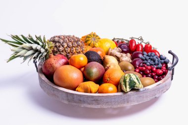 Tahta tepside beyaz bir arka planda izole edilmiş taze sebze ve meyveler..