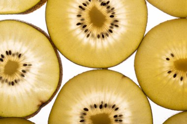 Kiwi Gold 'un arka planı. Siyah tohumlu sarı kivi dilimleri, yakın plan.