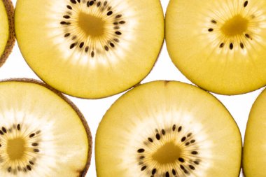Kiwi Gold 'un arka planı. Siyah tohumlu sarı kivi dilimleri, yakın plan.